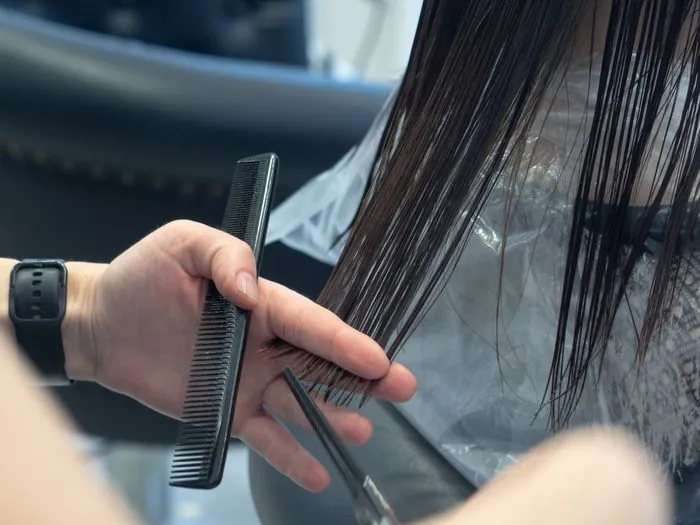 A comb and scissors in a barber's hands